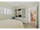 Bedroom featuring a bookcase with storage, cozy chair, and plantation shutters at 244 Saint Augustine # 605, Venice, FL 34285