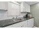 Practical kitchen featuring white cabinets, a stainless steel sink, and ample counter space at 244 Saint Augustine # 605, Venice, FL 34285