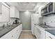 Well-lit kitchen featuring white appliances, white cabinets, and ample counter space at 244 Saint Augustine # 605, Venice, FL 34285