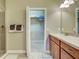 Bathroom featuring dual sinks, wood cabinets, a large mirror, and a glass shower enclosure at 275 Capulet Dr, Venice, FL 34292
