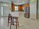 Well-lit kitchen with a bar, stainless steel appliances, tile floors, and wooden cabinets at 275 Capulet Dr, Venice, FL 34292