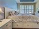 Main bedroom with blue accent wall, shuttered windows, and built in drawers under bed at 275 Capulet Dr, Venice, FL 34292