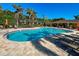 Beautiful community pool featuring lounge seating, mature palm trees, and a covered seating area at 275 Capulet Dr, Venice, FL 34292