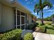 Home exterior featuring a screened in porch, well-maintained landscaping, and a mature palm tree at 275 Capulet Dr, Venice, FL 34292
