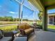 Cozy screened-in porch offering comfortable seating, complemented by tranquil water views and lush greenery at 275 Capulet Dr, Venice, FL 34292