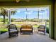 Inviting screened-in porch with comfortable wicker furniture and a picturesque view of the serene lake at 275 Capulet Dr, Venice, FL 34292