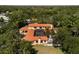 Expansive aerial view showcasing the home's tile roof, screened-in pool, and lush landscaping at 2750 Gocio Road Ext, Sarasota, FL 34235