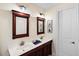 Well-lit bathroom featuring double sinks, a dark wood vanity, decorative mirrors and marine themed decorations at 2750 Gocio Road Ext, Sarasota, FL 34235
