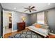 Cozy bedroom featuring hardwood floors, a full-size bed, and a view into an adjoining bathroom with vanity at 2750 Gocio Road Ext, Sarasota, FL 34235