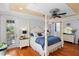 Elegant bedroom with hardwood floors, tray ceiling, and four-poster bed, offering access to a private balcony overlooking the lush landscape at 2750 Gocio Road Ext, Sarasota, FL 34235