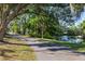 Scenic view of the long driveway lined with mature trees leading to the house and pond at 2750 Gocio Road Ext, Sarasota, FL 34235