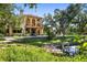 Two-story home features balconies, a tile roof, a green lawn, and mature trees at 2750 Gocio Road Ext, Sarasota, FL 34235