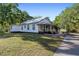 Exterior view of a well-maintained home with a metal roof and green lawn at 2750 Gocio Road Ext, Sarasota, FL 34235