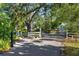 Welcoming front gate entrance with lush greenery, providing a sense of privacy and curb appeal at 2750 Gocio Road Ext, Sarasota, FL 34235