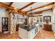 Spacious kitchen with stone accents, wooden beams, tile floor and central island at 2750 Gocio Road Ext, Sarasota, FL 34235