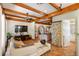 Bright living room with wood beams, tile floors, open floor plan, and stone archways at 2750 Gocio Road Ext, Sarasota, FL 34235
