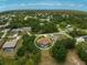 Aerial view of a home with a screened pool surrounded by lush trees in a tranquil neighborhood at 2834 Coolidge Ave, North Port, FL 34286