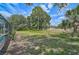 Expansive backyard showcasing lush green grass and mature trees in a tranquil setting at 2834 Coolidge Ave, North Port, FL 34286