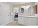 Bright bathroom with a double sink vanity, tile floors, and a door to the bedroom at 2834 Coolidge Ave, North Port, FL 34286