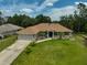 Aerial view of a well-maintained single-story home with a long driveway, lush green lawn, and mature landscaping at 2834 Coolidge Ave, North Port, FL 34286