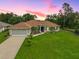 Charming single-story home featuring a well-maintained lawn, a two car garage and tropical landscaping at 2834 Coolidge Ave, North Port, FL 34286
