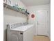 Clean laundry room featuring a full size washer and dryer with shelving and a Coca Cola decor at 2834 Coolidge Ave, North Port, FL 34286