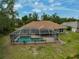 Aerial view of a screened-in pool area and a well-maintained backyard with a patio at 2834 Coolidge Ave, North Port, FL 34286
