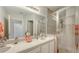 Bathroom featuring double sinks, a large mirror, and glass-enclosed walk-in shower at 301 Ravinia Cir # 301B2, Venice, FL 34292