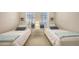 Bright bedroom featuring two twin beds, soft neutral decor, and sunlit windows at 301 Ravinia Cir # 301B2, Venice, FL 34292