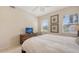 Comfortable bedroom featuring a TV and natural light from a double window view with rattan furniture at 301 Ravinia Cir # 301B2, Venice, FL 34292