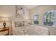 Sunlit bedroom featuring warm decor, paisley bedding and natural light from sunny windows at 301 Ravinia Cir # 301B2, Venice, FL 34292