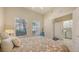 Cozy bedroom with natural light, patterned bedding, access to laundry and full bathroom at 301 Ravinia Cir # 301B2, Venice, FL 34292