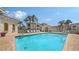 Relaxing community pool with palm trees and white lounge chairs on the brick patio at 301 Ravinia Cir # 301B2, Venice, FL 34292