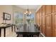 Elegant dining room with a large dining table, stylish chandelier, and views of lush greenery at 301 Ravinia Cir # 301B2, Venice, FL 34292