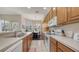 Modern kitchen with wooden cabinetry and stainless appliances adjacent to a dining area and great views at 301 Ravinia Cir # 301B2, Venice, FL 34292