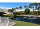 Scenic view of pond with fountain, bench seating, and landscaped surroundings at 301 Ravinia Cir # 301B2, Venice, FL 34292