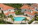 Aerial view showcases a pristine pool with sun loungers surrounded by lush landscaping and a community of homes at 301 Ravinia Cir # 301B2, Venice, FL 34292