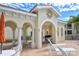 Poolside patio area with archways, outdoor seating, and a decorative sun face emblem at 301 Ravinia Cir # 301B2, Venice, FL 34292
