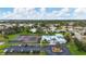 Aerial view showcases community pool, tennis courts, parking area, and lush landscaping at 3181 E Village Dr, Venice, FL 34293