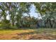 Backyard featuring mature trees and lush landscaping at 3181 E Village Dr, Venice, FL 34293
