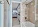 Bathroom featuring a shower-tub combo, neutral tile, and access to the main bedroom at 3181 E Village Dr, Venice, FL 34293
