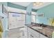 Bathroom featuring granite countertop, tile shower, and neutral decor at 3181 E Village Dr, Venice, FL 34293