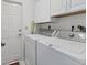 Functional laundry room equipped with modern washer and dryer units at 3181 E Village Dr, Venice, FL 34293
