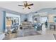 Bright living room with a ceiling fan, comfortable seating, and large windows at 3181 E Village Dr, Venice, FL 34293