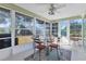 Bright sunroom with tile flooring, ceiling fan, and views of the backyard at 3181 E Village Dr, Venice, FL 34293