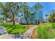 Beautifully landscaped backyard featuring lush lawn, a charming pathway, and a stylish waterfront home at 320 O Day, Englewood, FL 34223