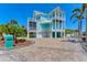Coastal home with a three-story facade, white columns, balconies, and a paved driveway at 320 O Day, Englewood, FL 34223