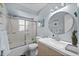 Well-lit bathroom with a glass-enclosed shower, updated vanity, and round mirror for a fresh, modern feel at 3355 Roslyn Rd, Venice, FL 34293