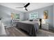 Relaxing bedroom features a ceiling fan, light blue walls, and views of the trees at 3355 Roslyn Rd, Venice, FL 34293