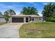 Single-story home featuring neutral paint, a dark gray garage door, and a concrete driveway at 3355 Roslyn Rd, Venice, FL 34293